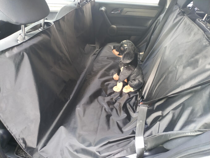 Spott Pet crni prekrivač 144 × 160 cm razapet preko zadnjeg sedišta, sa pojasom provučenim kroz otvor